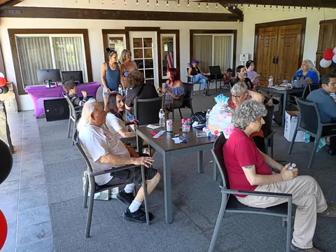 Guests chatting at tables across the covered patio.