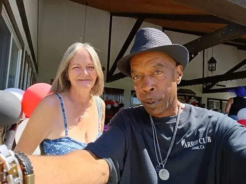 Two guests posing beside balloons on the patio, one wearing an Arrid Club shirt.
