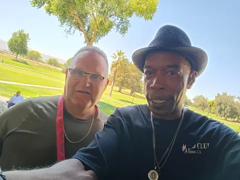 Two guests posing with the green golf course behind them.
